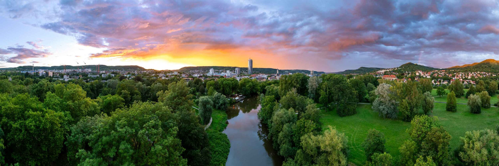 Panorama Bilder vom Sonnenuntergang im Stadtpark Jena mit glühendem Himmel und Regenbogen